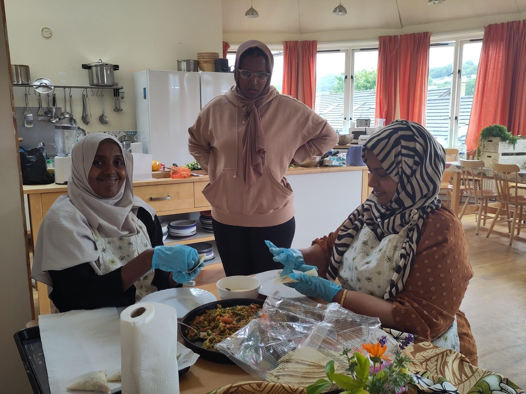 Women sharing food and conversation at a community table